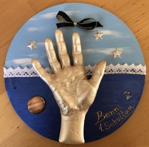 Abdruck von Kinderhand auf runder Platte