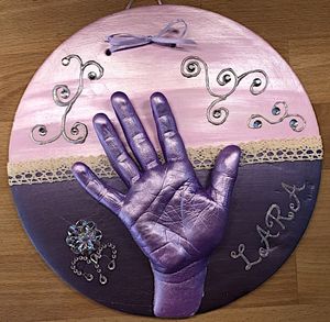 Abdruck von Kinderhand auf runder Platte